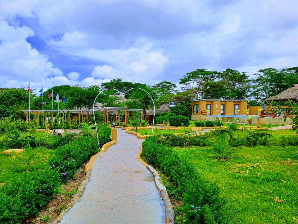 Garden path leading through the grounds of Hunter's Luxury Manor with flags and acacia trees