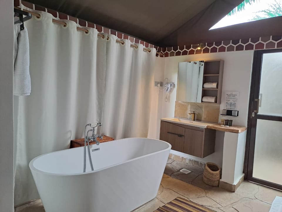 En-suite bathroom with a freestanding soaking tub and stone floor